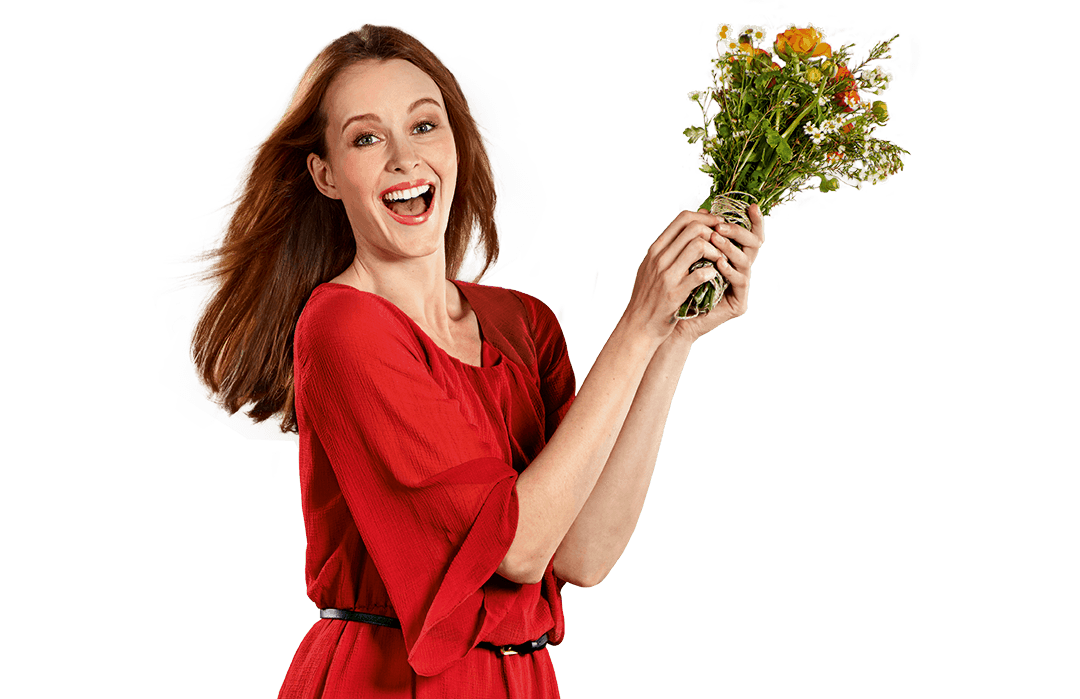 A woman in a red dress smiling at the camera while holding a bouquet of flowers